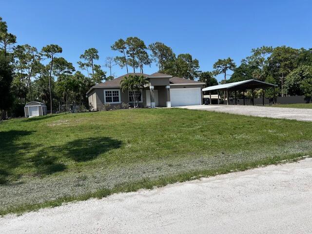 14413 71st Pl N, Loxahatchee, FL 33470 - view of front of property with driveway, a front lawn, and an attached garage
