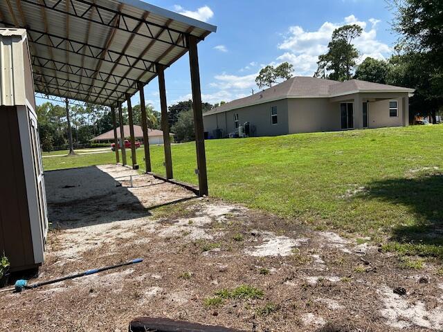 14413 71st Pl N, Loxahatchee, FL 33470 - view of green lawn with a carport