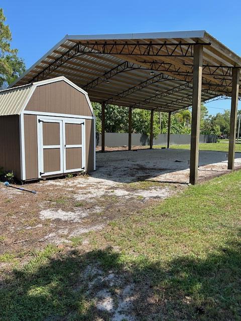 14413 71st Pl N, Loxahatchee, FL 33470 - view of vehicle parking with a storage unit and a detached carport