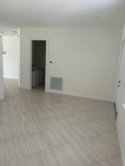 14413 71st Pl N, Loxahatchee, FL 33470 - unfurnished room featuring baseboards and washer and dryer