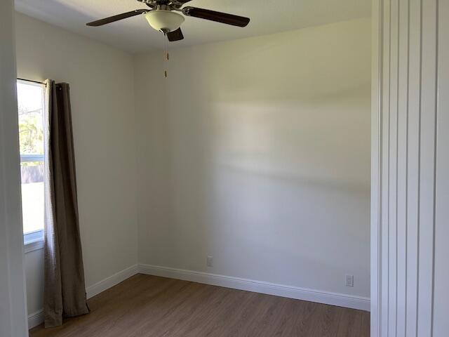 14413 71st Pl N, Loxahatchee, FL 33470 - spare room with wood finished floors, a ceiling fan, healthy amount of natural light, and baseboards