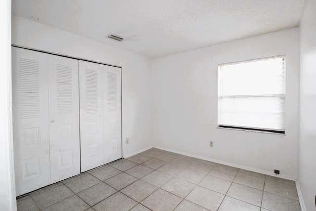 1561 SE Arenson Ln, Port Saint Lucie, FL 34952 - unfurnished bedroom with light tile patterned flooring, a closet, and baseboards