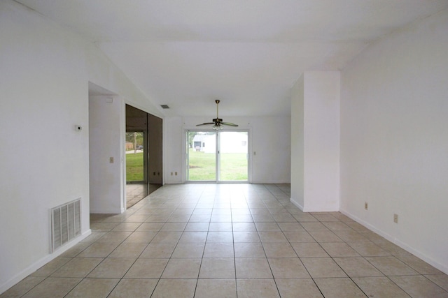 1561 SE Arenson Ln, Port Saint Lucie, FL 34952 - spare room featuring ceiling fan, light tile patterned floors, lofted ceiling, and baseboards