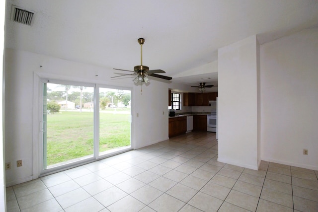 1561 SE Arenson Ln, Port Saint Lucie, FL 34952 - unfurnished living room featuring ceiling fan, vaulted ceiling, light tile patterned floors, and baseboards