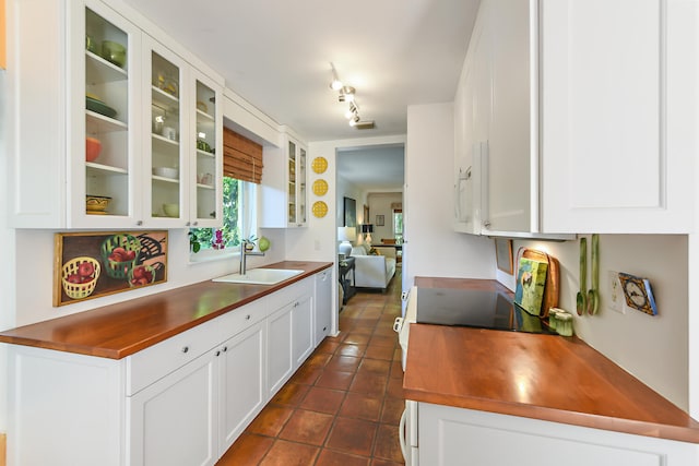 1228 George Bush Blvd Unit 4, Delray Beach, FL 33483 - kitchen with a sink, white microwave, dark tile patterned flooring, glass insert cabinets, and white cabinets