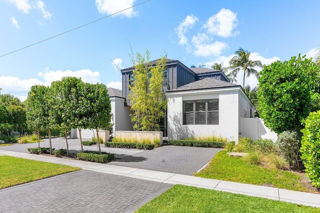 view of front facade featuring fence and stucco siding