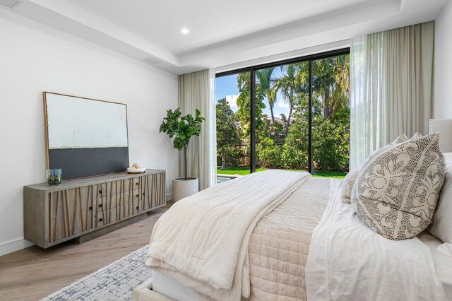 bedroom with wood finished floors, access to exterior, and recessed lighting