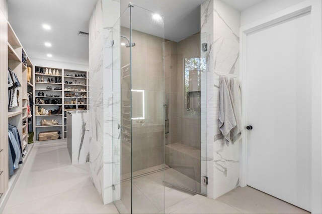full bath featuring a shower stall, a walk in closet, recessed lighting, and tile patterned flooring