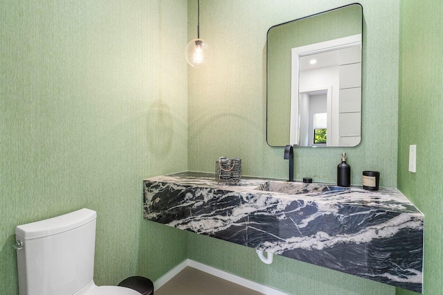 half bathroom featuring toilet and a sink