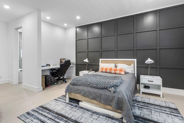 bedroom featuring a decorative wall, baseboards, recessed lighting, a desk, and tile patterned floors