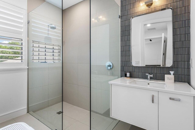 bathroom with tile patterned floors, walk in shower, vanity, and tile walls