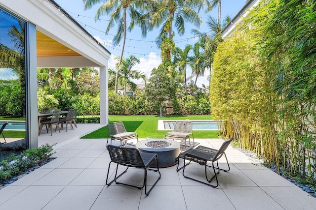 view of patio featuring a fire pit and an outdoor pool