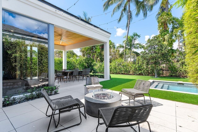 view of patio / terrace featuring an outdoor fire pit, a ceiling fan, an outdoor pool, and outdoor dining area