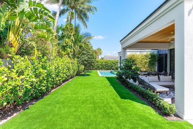 view of green lawn with ceiling fan
