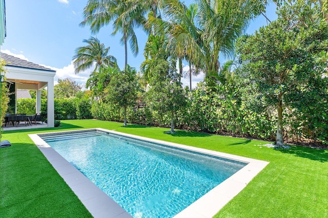 swimming pool featuring a yard and a patio