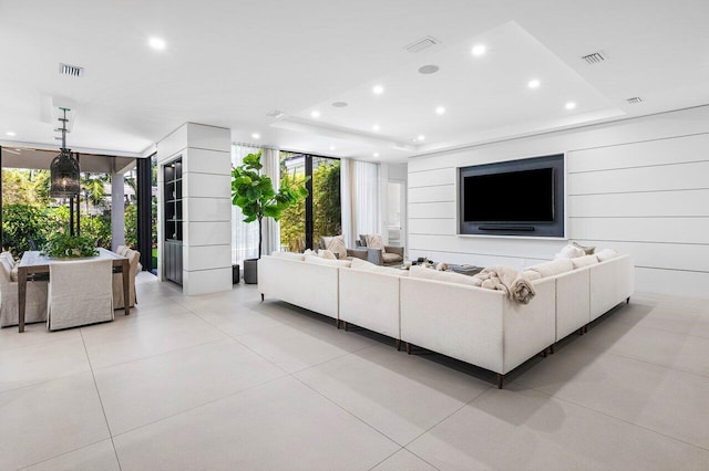 living area featuring floor to ceiling windows, recessed lighting, a raised ceiling, and light tile patterned flooring