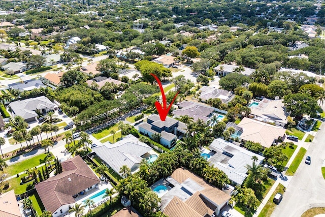 aerial view of property and surrounding area featuring nearby suburban area and a pool area