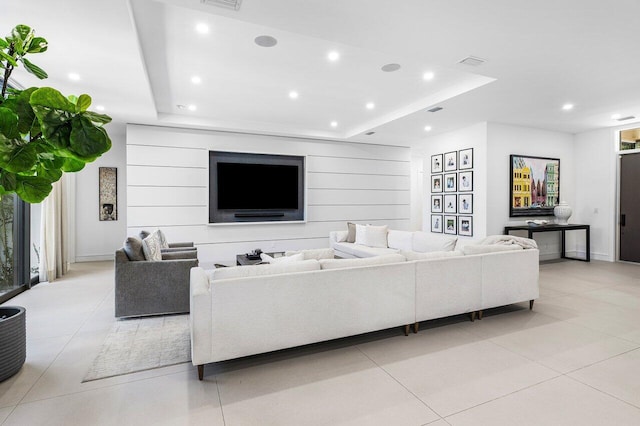 living area featuring a tray ceiling, recessed lighting, and light tile patterned floors