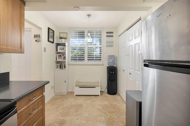 2070 Homewood Blvd Unit 1115, Delray Beach, FL 33445 - kitchen featuring freestanding refrigerator, dark countertops, brown cabinetry, range with electric stovetop, and hanging light fixtures