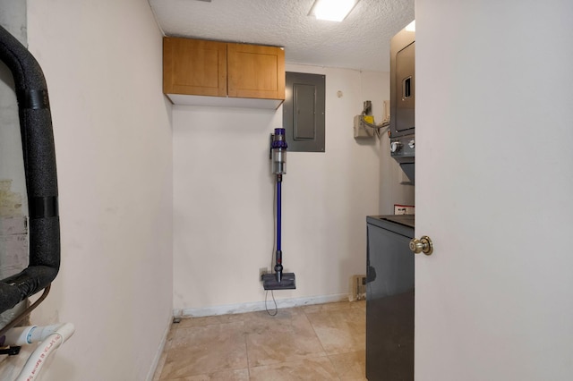 2070 Homewood Blvd Unit 1115, Delray Beach, FL 33445 - washroom featuring stacked washer and clothes dryer, electric panel, baseboards, and a textured ceiling