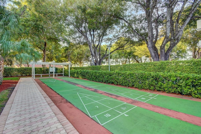2070 Homewood Blvd Unit 1115, Delray Beach, FL 33445 - surrounding community featuring shuffleboard, a pergola, and view of wooded area