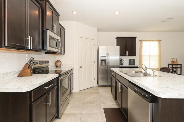 567 SW Paar Dr, Port Saint Lucie, FL 34953 - kitchen featuring stainless steel appliances, a sink, dark brown cabinetry, light countertops, and recessed lighting