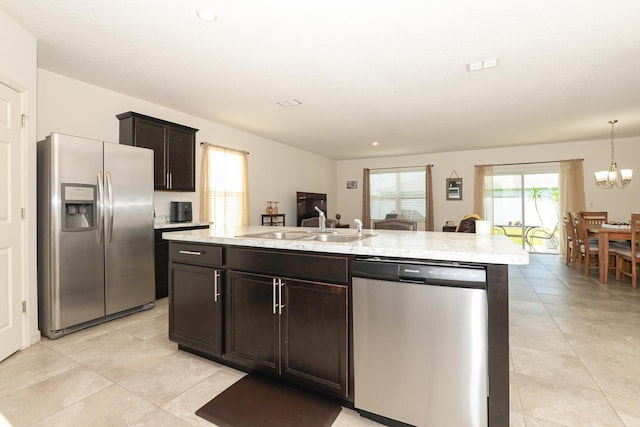 567 SW Paar Dr, Port Saint Lucie, FL 34953 - kitchen featuring stainless steel appliances, dark brown cabinetry, light tile patterned flooring, a sink, and an island with sink