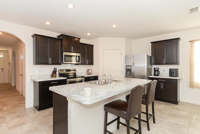 567 SW Paar Dr, Port Saint Lucie, FL 34953 - kitchen featuring stainless steel appliances, a sink, arched walkways, light countertops, and recessed lighting