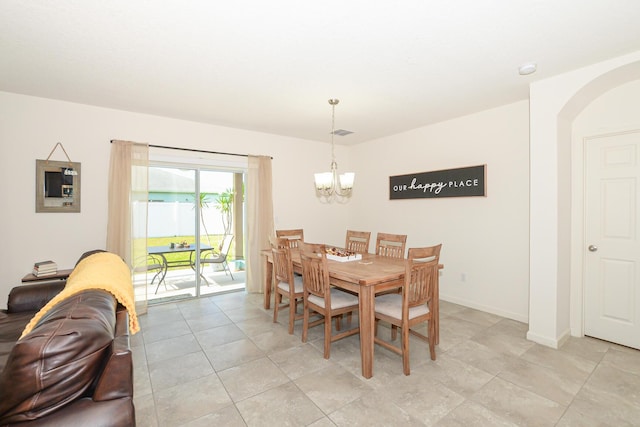 567 SW Paar Dr, Port Saint Lucie, FL 34953 - dining space with a chandelier, arched walkways, light tile patterned floors, and baseboards