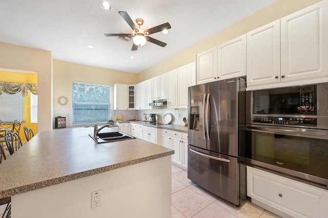 kitchen with stainless steel appliances, a sink, a ceiling fan, under cabinet range hood, and white cabinetry