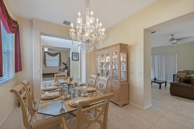 dining room featuring light tile patterned floors, baseboards, ceiling fan, and a chandelier