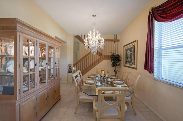 dining area featuring a chandelier, light tile patterned flooring, stairway, and baseboards