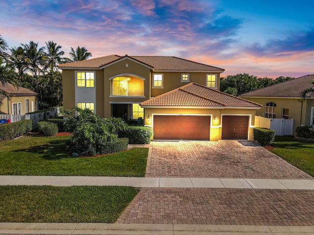 mediterranean / spanish home featuring a tiled roof, stucco siding, driveway, and an attached garage