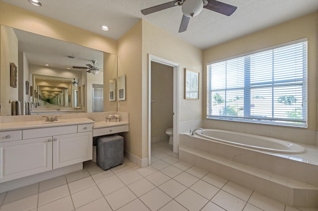 bathroom featuring ceiling fan, toilet, a garden tub, tile patterned floors, and vanity