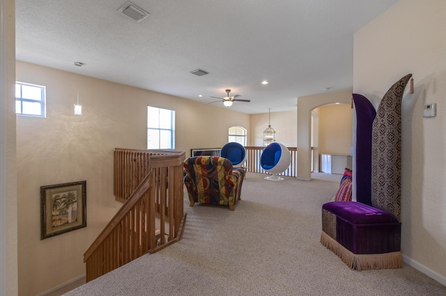 corridor featuring an upstairs landing, carpet floors, baseboards, arched walkways, and recessed lighting