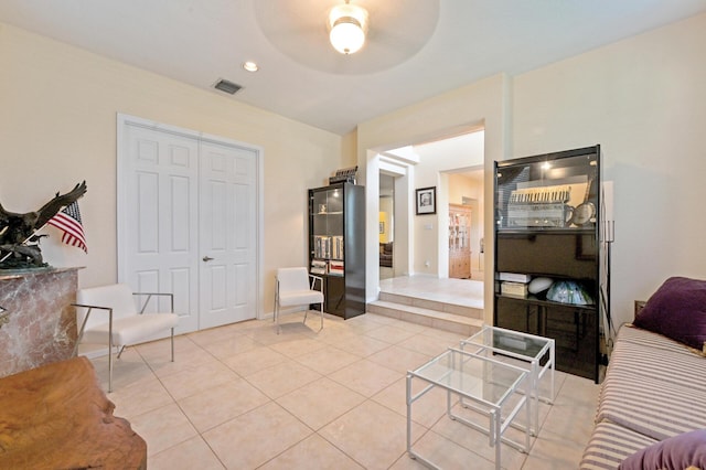 living area featuring light tile patterned flooring and a ceiling fan