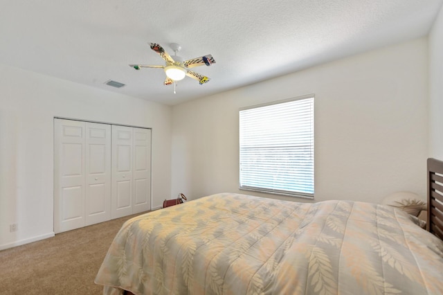 carpeted bedroom with a ceiling fan and a closet