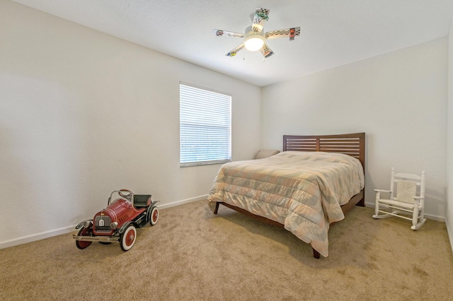 bedroom featuring light colored carpet, baseboards, and a ceiling fan
