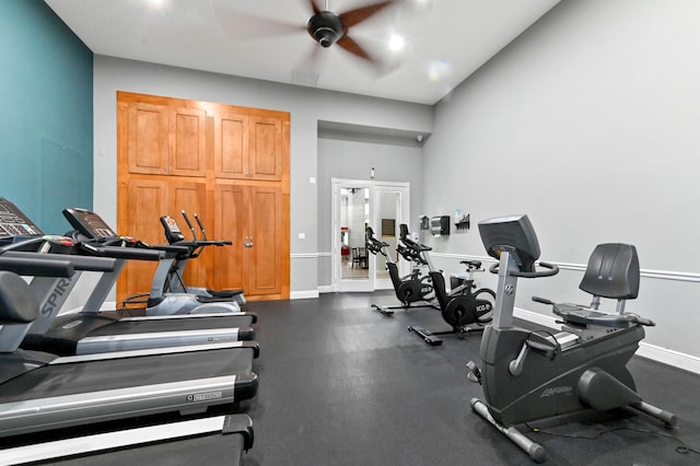 exercise room with a ceiling fan and baseboards