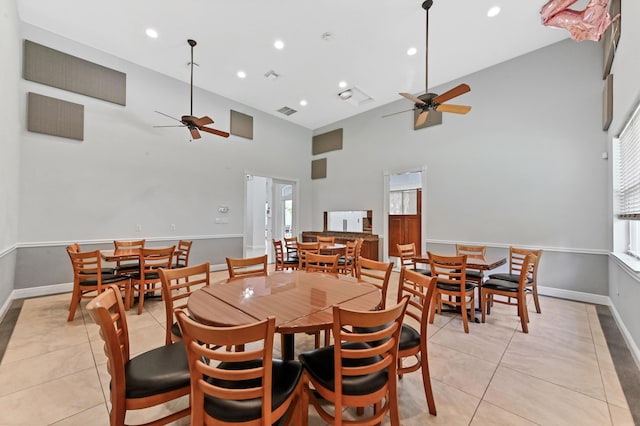 dining room with a ceiling fan, light tile patterned flooring, a high ceiling, recessed lighting, and baseboards