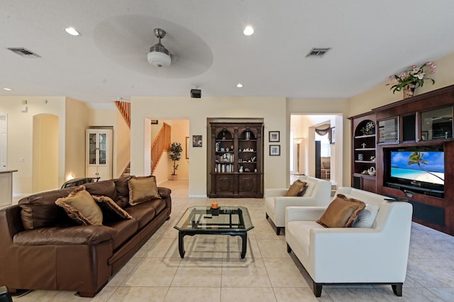 living area with stairway, ceiling fan, recessed lighting, and arched walkways