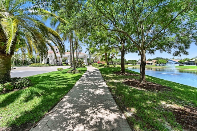 view of home's community with a water view and a yard