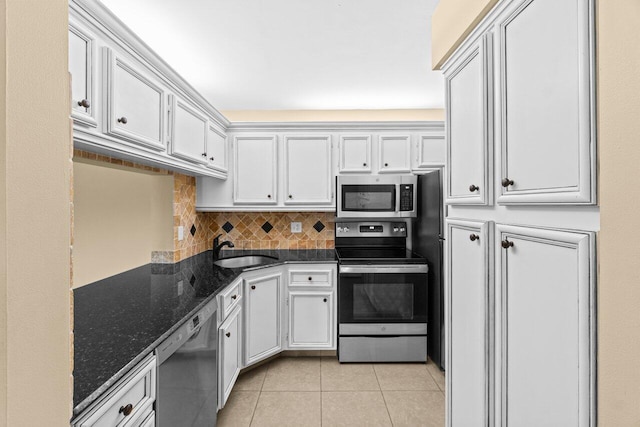 629 Sea Pine Way Unit D1, Greenacres, FL 33415 - kitchen featuring stainless steel appliances, a sink, light tile patterned floors, decorative backsplash, and dark stone countertops