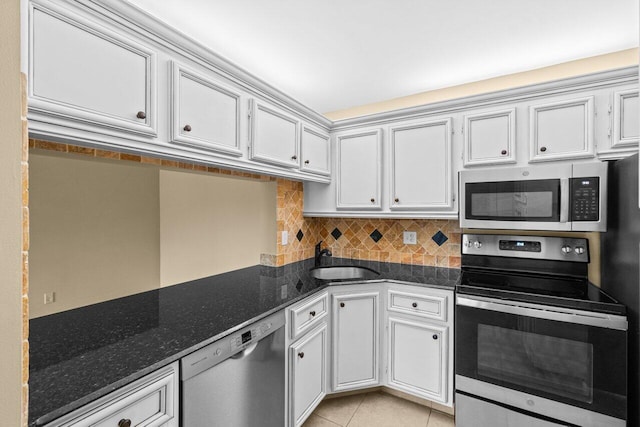 629 Sea Pine Way Unit D1, Greenacres, FL 33415 - kitchen featuring stainless steel appliances, a sink, decorative backsplash, light tile patterned flooring, and dark stone countertops