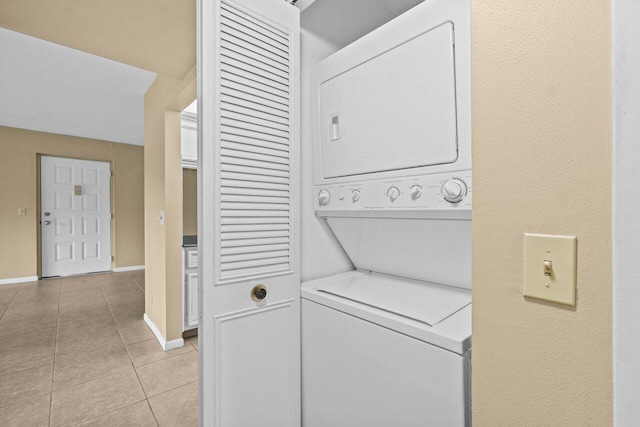 629 Sea Pine Way Unit D1, Greenacres, FL 33415 - laundry room featuring stacked washer / dryer, light tile patterned floors, and baseboards