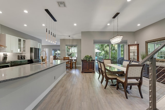 127 Via Castilla, Jupiter, FL 33458 - dining room with light wood-style floors, recessed lighting, baseboards, and a chandelier