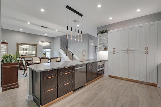 127 Via Castilla, Jupiter, FL 33458 - kitchen with appliances with stainless steel finishes, a sink, light wood-style flooring, open shelves, and pendant lighting