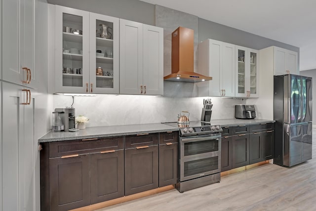 127 Via Castilla, Jupiter, FL 33458 - kitchen with stainless steel appliances, wall chimney exhaust hood, light wood finished floors, white cabinets, and glass insert cabinets
