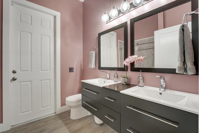 127 Via Castilla, Jupiter, FL 33458 - full bath featuring double vanity, toilet, wood finished floors, a shower, and baseboards