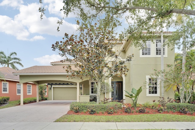 127 Via Castilla, Jupiter, FL 33458 - view of front of home featuring decorative driveway, stucco siding, an attached garage, and a tiled roof